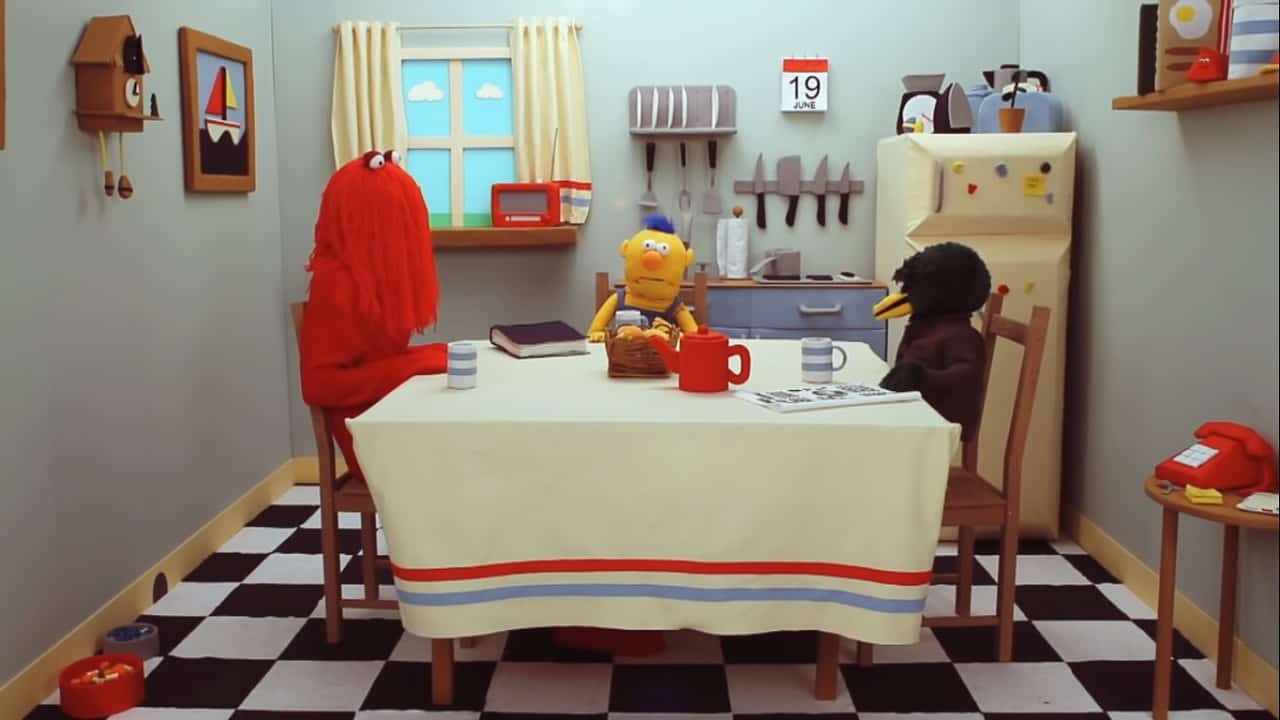 Screenshot from Don't Hug Me I'm Scared, with Red Guy, Yellow Guy, and Duck Guy sitting at the kitchen table